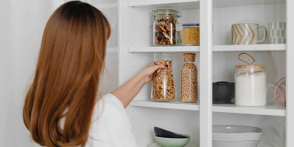 An example of a woman organizing kitchen cabinets.