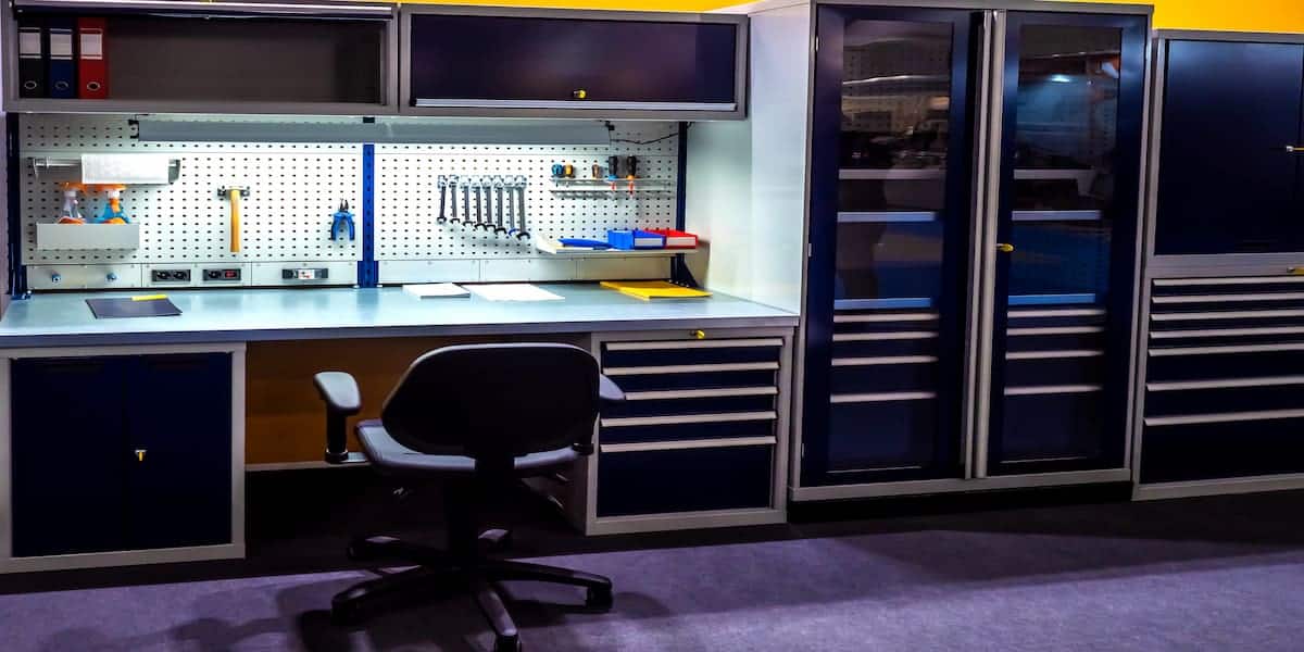 Organized garage workspace featuring sleek storage cabinets, a pegboard with tools, and a workbench, showcasing modern garage cabinet ideas for efficient organization.